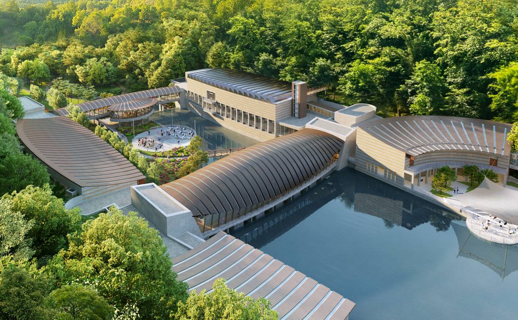 Modern architectural complex with curved roofs, trees, central plaza, water reflections.