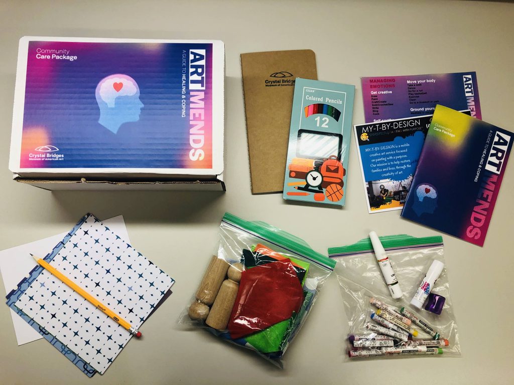 Art Mends box with contents Art Mends package with notebook, colored pencils, booklet, cards, crayons, markers, crafting materials.