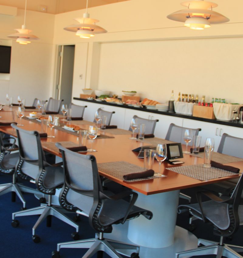 Meeting Space Modern conference room with a long table, office chairs, and a sideboard with food and drinks.