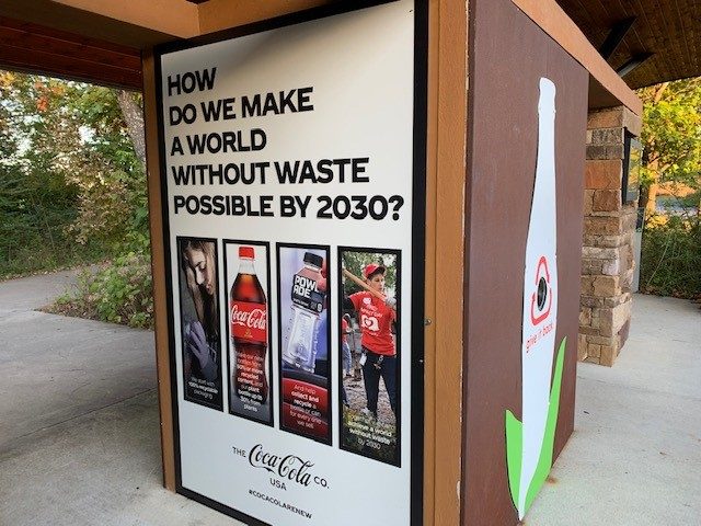 Recycling Coca-Cola ad promoting a waste-free world by 2030 with images of recycling and sustainability.
