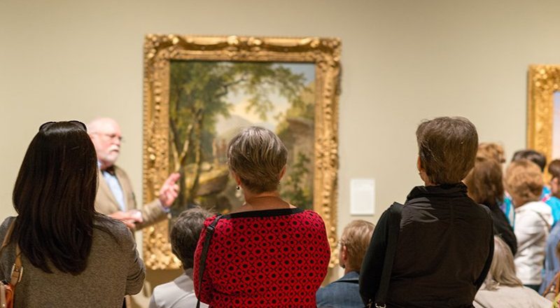 Group Tour Art gallery group tour observing a scenic landscape painting.