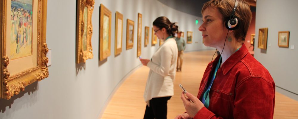 Guest listening to audio guide in gallery Guest listening to audio guide in gallery
