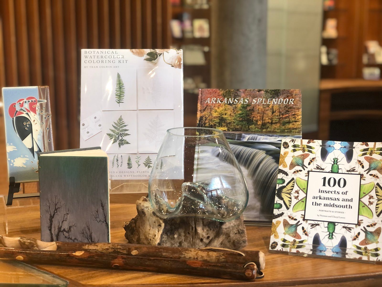 Merchandise Books displayed on wood with titles and decorative glass piece.