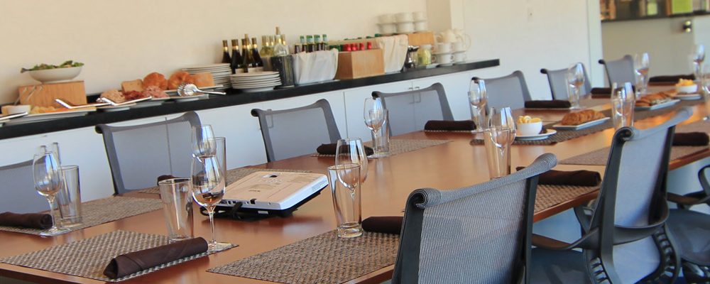 Meting Space Conference room with a long table, ergonomic chairs, and a buffet with food and beverages.