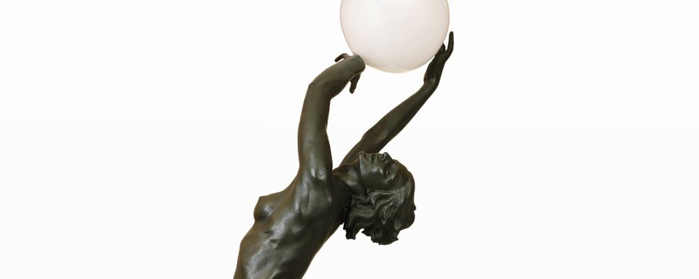 Bronze sculpture of a female figure with raised arms holding a sphere.