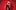 Person in front of red curtains, wearing sequined bra, black pants, hat, hands on hips confidently.