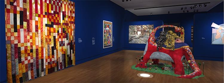State of the Art 2020; JooYoung Choi, Time for You and Joy to Get Acquainted, 2017, Wooden armature, fabric, polyfoam, 108 × 115 × 85 in. Courtesy of Nancy Littlejohn Fine Art. Art gallery with blue walls, large colorful quilt, framed artworks, and vibrant floor sculpture.